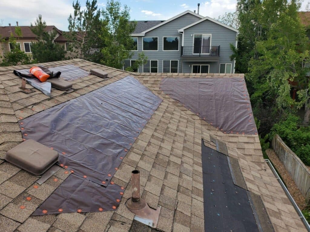 Emergency roof tarp protecting damaged areas of a Fort Worth home