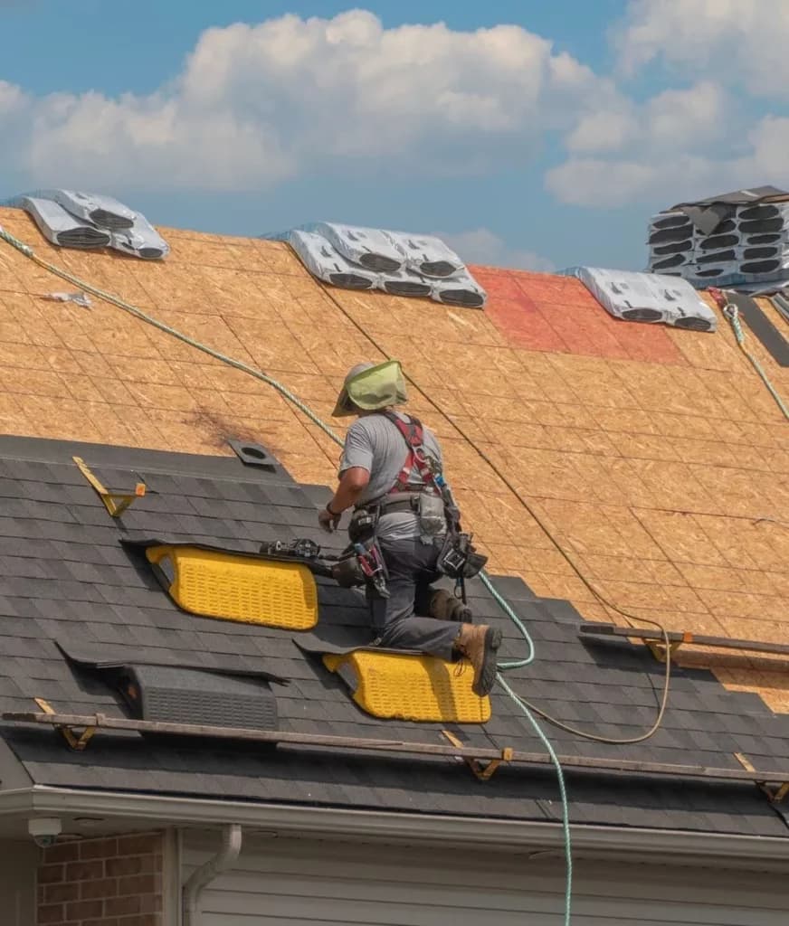Roofer installing shingles over a new residential roof deck
