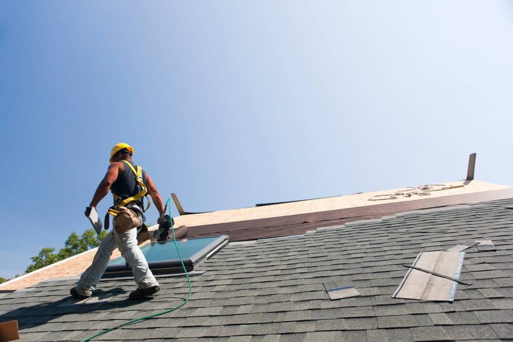 Skilled roofer working on a shingle roof