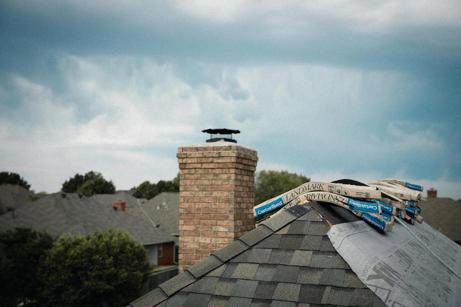 Roofing materials staged beneath storm clouds